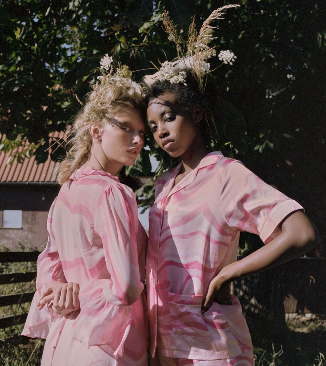 Two women wearing pink leaning on eachother